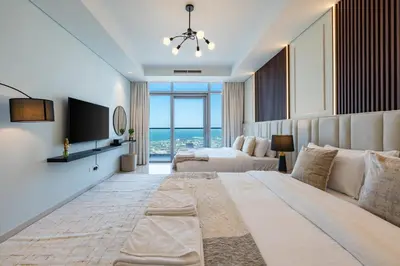 a bedroom with a large bed and a view of the ocean at 3 Bedroom - Pool Access - 7 mins to Dubai Mall - Sun Set View in Dubai