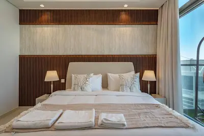 a bedroom with a large white bed with two lamps at 3 Bedroom - Pool Access - 7 mins to Dubai Mall - Sun Set View in Dubai