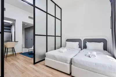 a bedroom with a white bed and a large mirror at Studio Haven with Pool, Tennis and Kid's Playground in Dubai