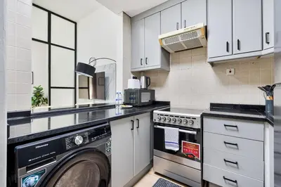 a kitchen with a washer and dryer in it at Studio Haven with Pool, Tennis and Kid's Playground in Dubai