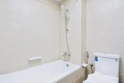 a bathroom with a tub and a toilet and a shower at Studio Haven with Pool, Tennis and Kid's Playground in Dubai