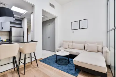 a living room with a couch and a table at Studio Haven with Pool, Tennis and Kid's Playground in Dubai