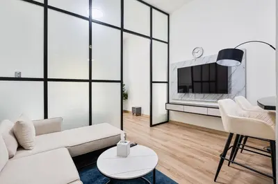 a living room with a white couch and a tv at Studio Haven with Pool, Tennis and Kid's Playground in Dubai