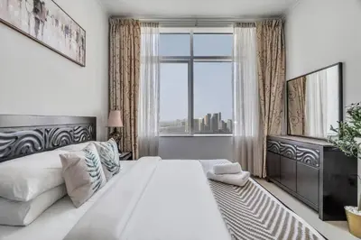 a white bedroom with a large bed and a window at GuestReady - Fantastic retreat with Palm views in Dubai
