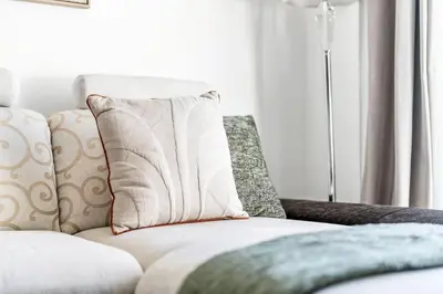 a white couch with a pillow and a lamp at GuestReady - Fantastic retreat with Palm views in Dubai