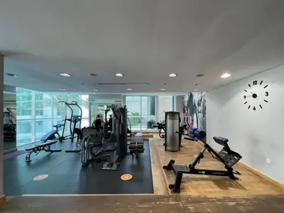 a gym with cardio equipment and a clock on the wall at GuestReady - Fantastic retreat with Palm views in Dubai