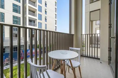 a balcony with a table and two chairs and a table at Elegant 1BR with Pool, Gym Access and Kid's Play Area in Dubai