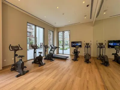 a gym with many exercise bikes in a room at Elegant 1BR with Pool, Gym Access and Kid's Play Area in Dubai
