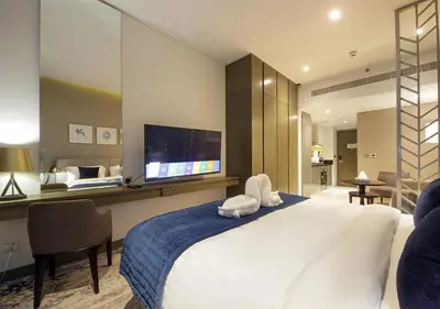 a bedroom with a large bed with a tv on the wall at Burj Khalifa & Canal View LuxeStudio in DAMACPrive in Dubai