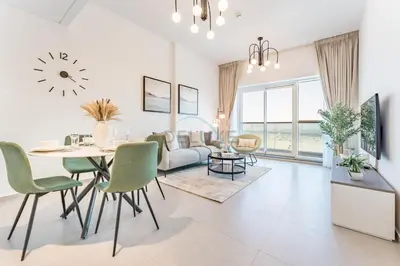 a dining room and living room with a table and chairs at Near Dubai Miracle Garden 1BR with Private Balcony, Orchid Residence, Al Barsha South by Deluxe Holiday Homes in Dubai