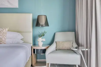 a bedroom with a bed and a chair and a lamp at GuestReady - Stylish home in Business Bay in Dubai