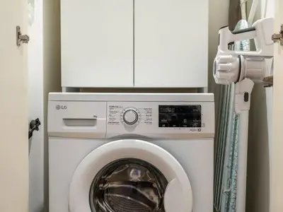 a washer and dryer with a cabinet above it at Contemporary 1BR in Collective 2.0 Luxury and Comfort in Dubai