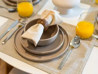 a bowl on a table with a napkin and a glass of orange juice at Contemporary 1BR in Collective 2.0 Luxury and Comfort in Dubai