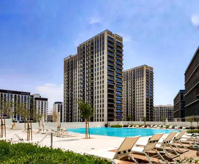 a swimming pool with lounge chairs and tall buildings at Contemporary 1BR in Collective 2.0 Luxury and Comfort in Dubai