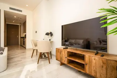 a living room with a large television and a bedroom at New Build Luxury with Burj View at Peninsula 5, Business Bay in Dubai