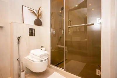 a bathroom with a toilet and a glass shower at New Build Luxury with Burj View at Peninsula 5, Business Bay in Dubai
