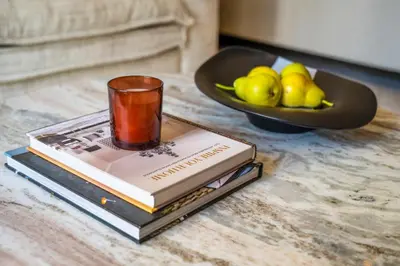 a cup on top of two books and a bowl of fruit at New Build Luxury with Burj View at Peninsula 5, Business Bay in Dubai