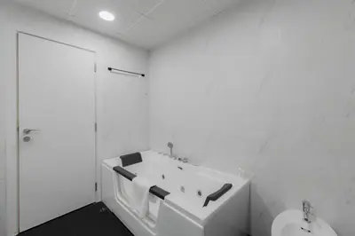 a white bathroom with a tub and a toilet at Short Stay Apartment Shams 1 Jumeirah Beach Residence 2 Bed Sleeps 6 - DVH HOLIDAY HOMES in Dubai