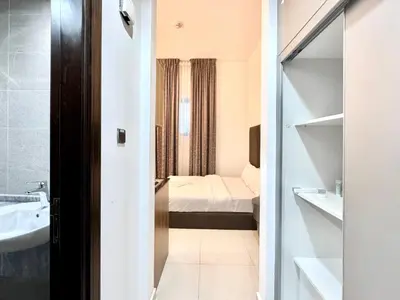 a small bathroom with a sink and a bed at Al Manara Classic Cozy Studio in Dubai
