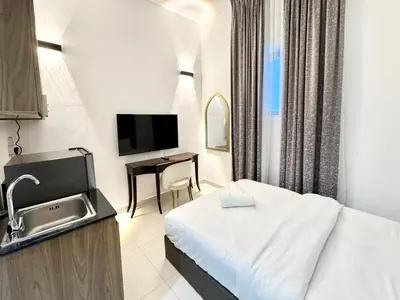 a small hotel room with a bed and a sink at Al Manara Classic Cozy Studio in Dubai