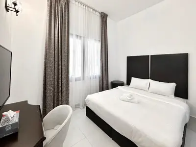 a bedroom with a large white bed and a chair at Al Manara Classic Deluxe Studio in Dubai