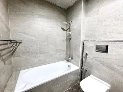 a bathroom with a bath tub and a toilet at Al Manara Classic Deluxe Studio in Dubai