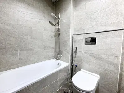 a bathroom with a tub and a toilet and a sink at Al Manara Classic Deluxe Studio in Dubai