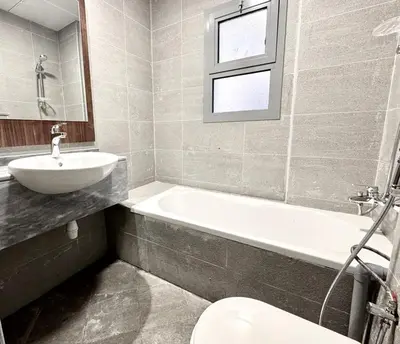 a bathroom with a sink and a tub and a toilet at Al Manara Classic Executive Studio in Dubai