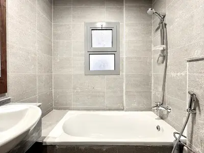 a bathroom with a tub and a sink and a window at Al Manara Classic Executive Studio in Dubai