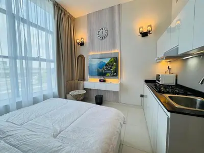 a bedroom with a bed and a sink and a clock at Al Manara Premium Deluxe Sheikh Zayed View Studio in Dubai