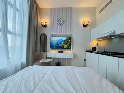 a bedroom with a white bed and a kitchen at Al Manara Premium Deluxe Sheikh Zayed View Studio in Dubai