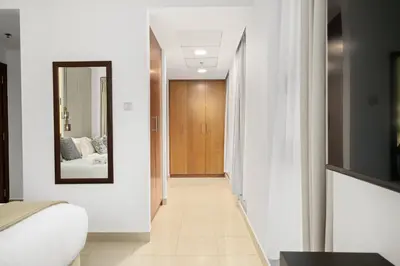 a hallway leading to a bedroom with a bed and a mirror at Standpoint Tower by Luxe Living in Dubai