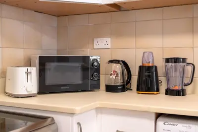 a kitchen counter with a microwave and some appliances at JBR Rimal By Luxe Living - Dubai Eye View in Dubai