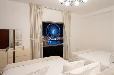 a bedroom with two beds and a window with a ferris wheel at JBR Rimal By Luxe Living - Dubai Eye View in Dubai