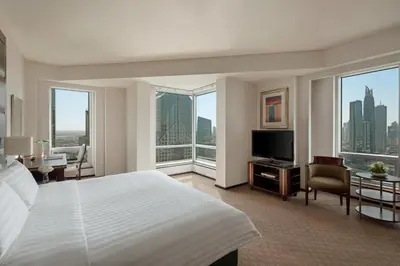 a hotel room with a bed and a tv and windows at Shangri-La Apartments in Dubai