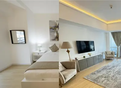 a bedroom with a bed and a room with a tv at Appartement Moderne Dubai Marina in Dubai