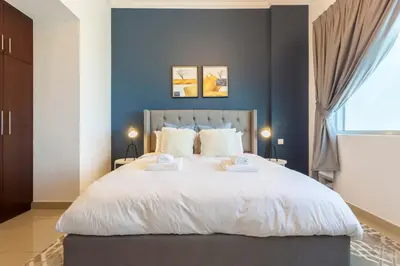 a bedroom with a large bed with two towels at GuestReady - Modern Apartment with Gorgeous Views in Dubai