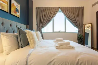 a bedroom with a white bed with towels on it at GuestReady - Modern Apartment with Gorgeous Views in Dubai