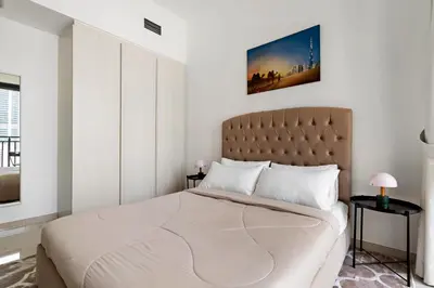 a bedroom with a large bed with white walls at Stylish 1BR In Zada Tower With Pool Views in Dubai