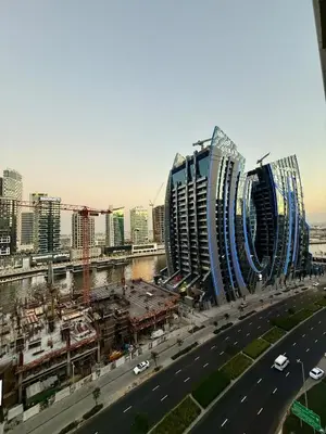 two tall buildings in a city next to a highway at DAMAC Reva 5 mins Walk from Dubai mall in Dubai