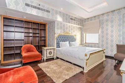 a bedroom with a king sized bed and a chair at Artistic penthouse with amazing JBR Beach and sea view in Dubai
