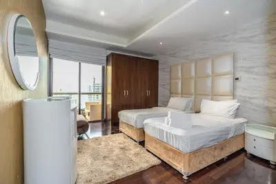 a large bedroom with two beds and a mirror at Artistic penthouse with amazing JBR Beach and sea view in Dubai