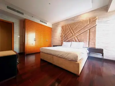 a bedroom with a large bed with a wooden wall at Artistic penthouse with amazing JBR Beach and sea view in Dubai