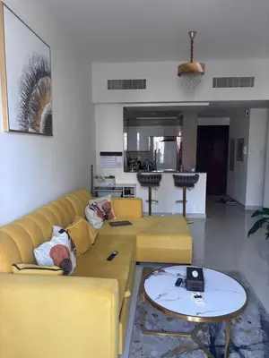 a living room with a yellow couch and a table at Burj Views 2 BHK Apartment in Dubai