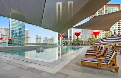 a row of chairs sitting next to a swimming pool at Mag 318 - 3 min walk to Dubai Mall - Luxury Studio - Pool & SLS View in Dubai