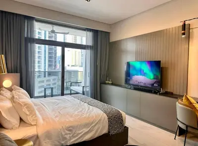 a bedroom with a bed and a flat screen tv at Mag 318 - 3 min walk to Dubai Mall - Luxury Studio - Pool & SLS View in Dubai