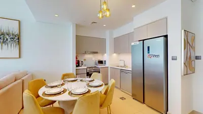 a kitchen and dining room with a table and chairs at Act One Act Two - Sophisticated Two Bedroom in Dubai