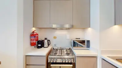 a kitchen with a stove and a microwave at Act One Act Two - Sophisticated Two Bedroom in Dubai