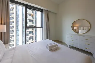 a bedroom with a white bed and a mirror at Act One Act Two - Sophisticated Two Bedroom in Dubai