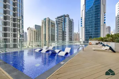 a swimming pool in a city with tall buildings at Cozy Studio with City Views at Bayz by Danube by BMS in Dubai